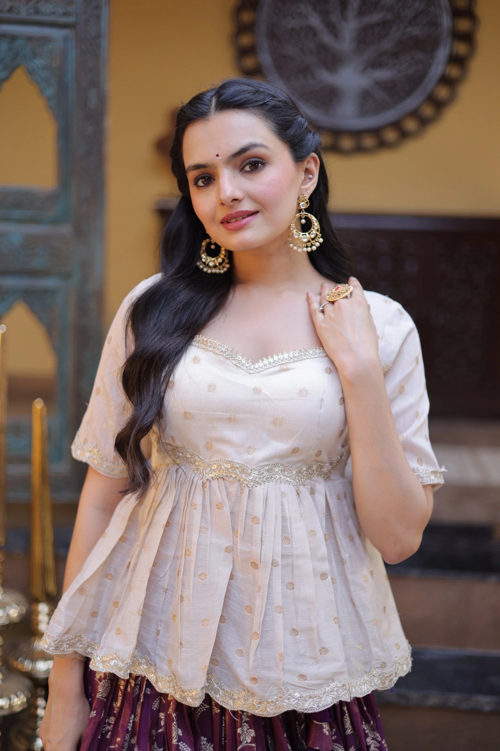 Woman in traditional attire with jewelry in an indoor setting