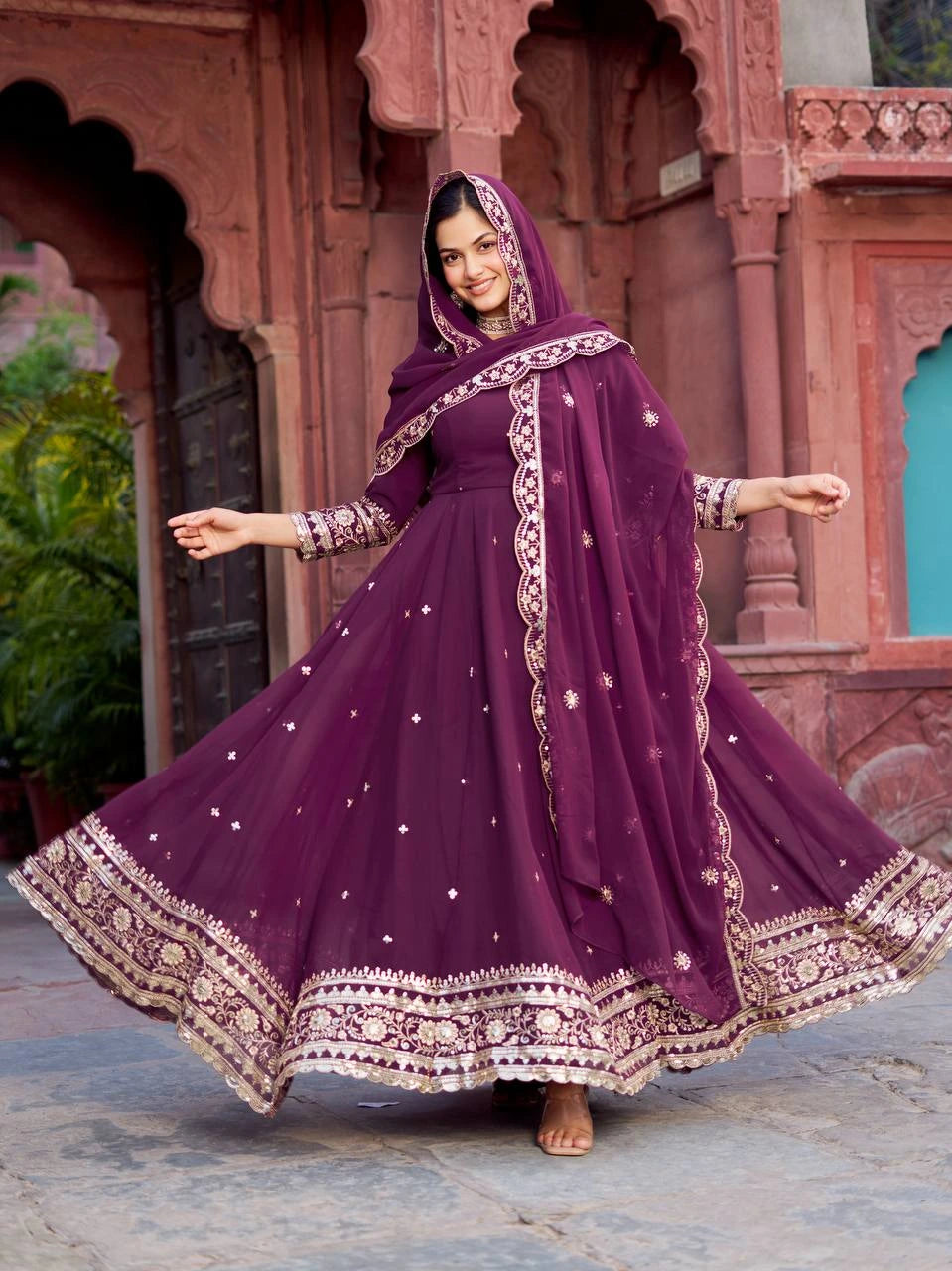 The outfit is adorned with intricate silver and gold floral embroidery along the borders and hemline.
