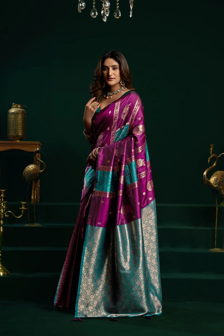 Woman wearing a purple and blue saree with a dark green background