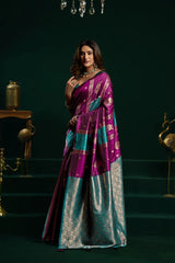 Woman wearing a purple and blue saree with a dark green background