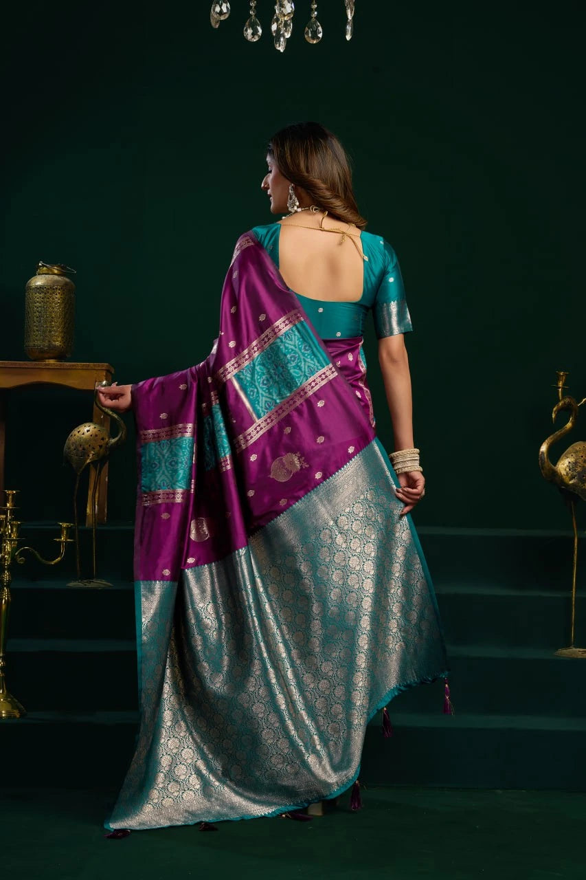 Woman in a traditional saree standing on a dark green staircase.