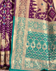 Traditional purple and green saree with intricate patterns