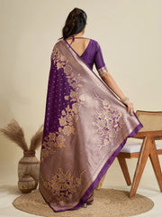 Woman wearing a purple saree with floral patterns in a minimalistic setting