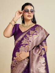 Woman wearing a purple saree with floral patterns on a beige background