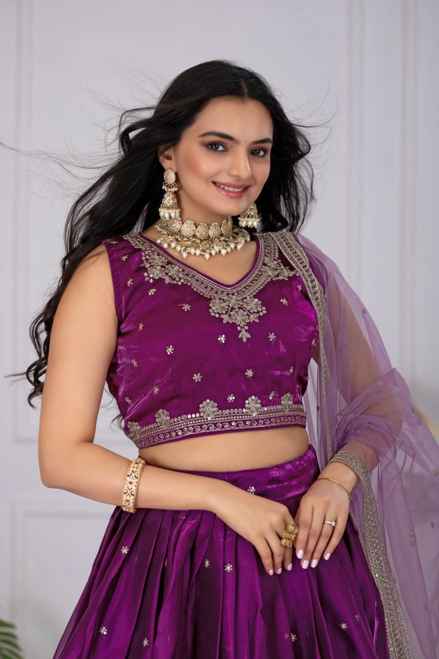 Woman wearing a purple traditional outfit with jewelry against a white background