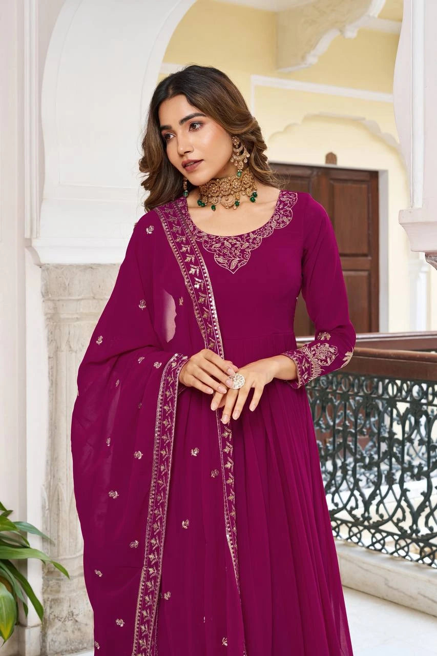 A close-up shot focusing on the bodice and jewelry. The woman is looking away with a soft expression, showcasing the detailed gold threadwork on the neckline and the shimmering sequined border of the magenta dupatta.