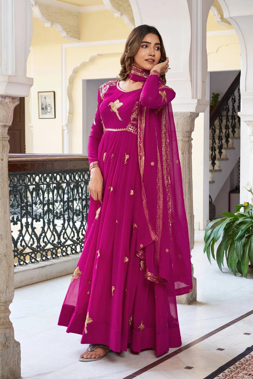 Traditional Indian party wear suit in wine shade with intricate embroidery showcased online