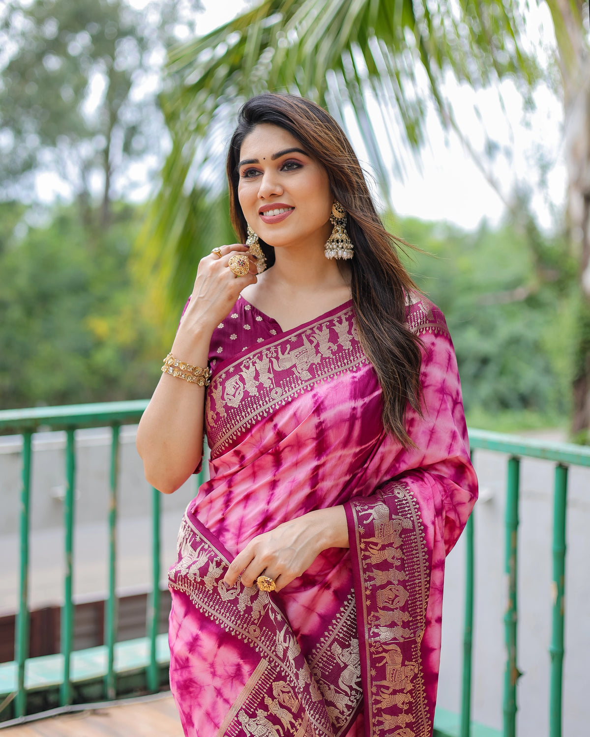 Woman wearing a pink saree with a green background