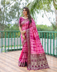Woman wearing a pink saree with a green outdoor background