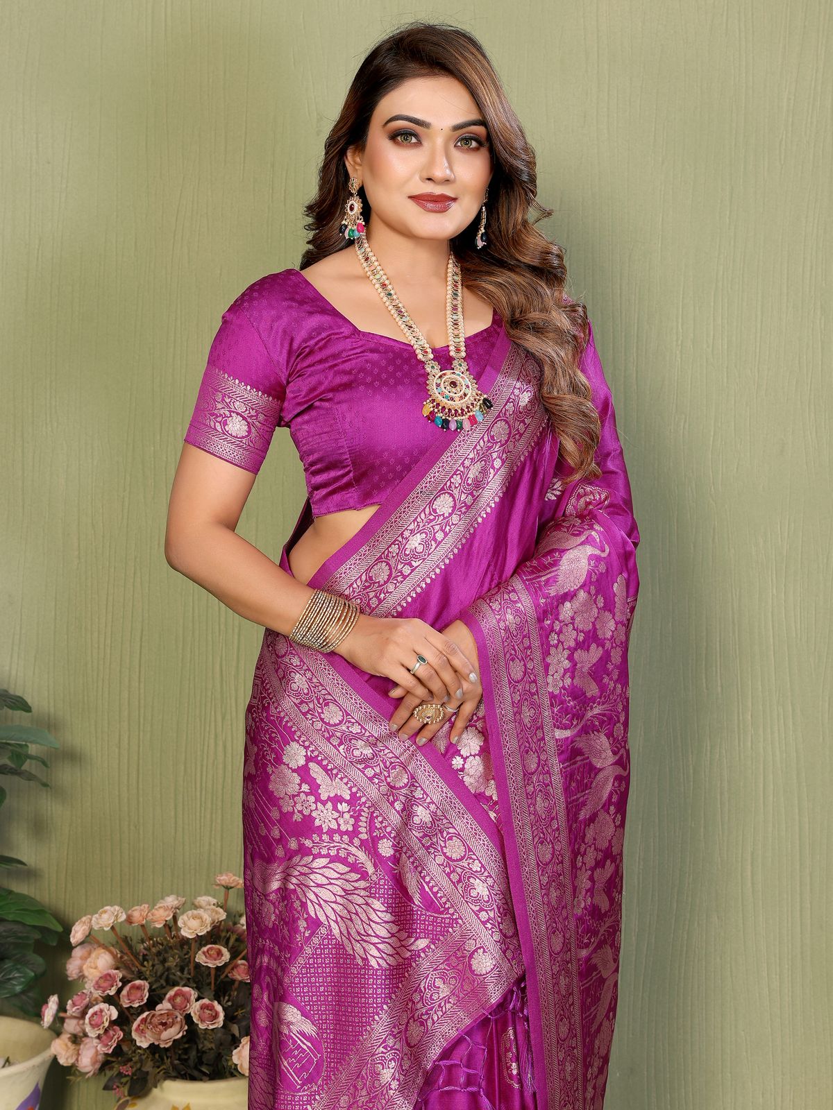 Woman wearing a purple saree with a green background