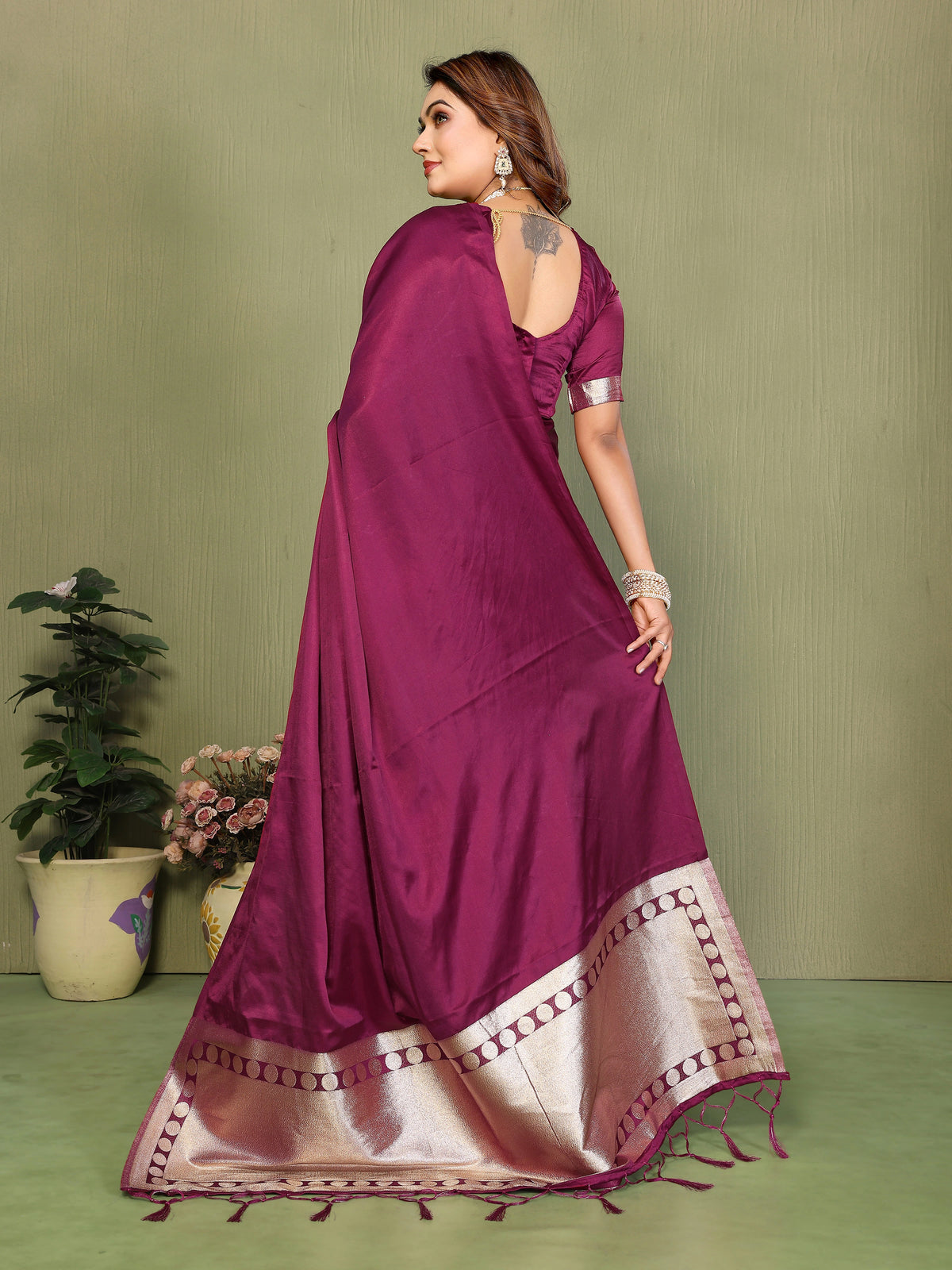 Woman wearing a purple saree with a green background