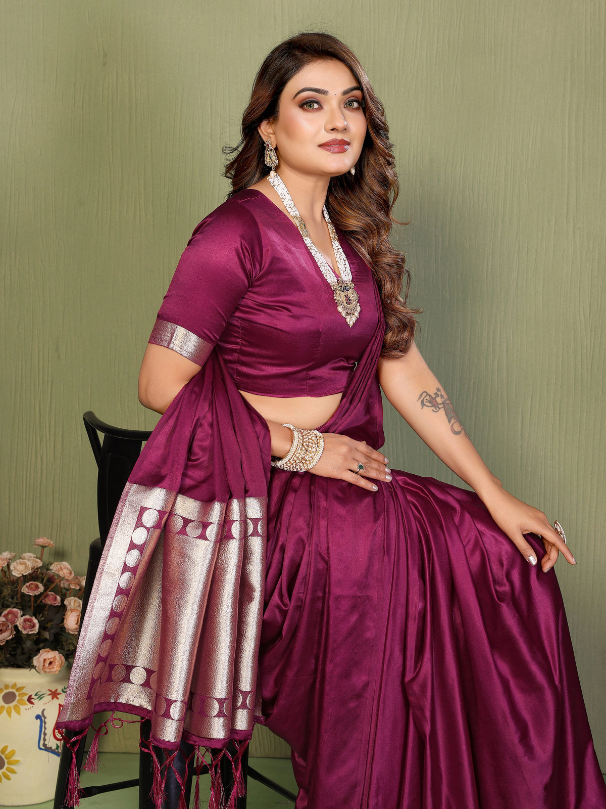 Woman wearing a purple saree with a green background