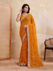 Woman wearing a bright orange saree with a beige background