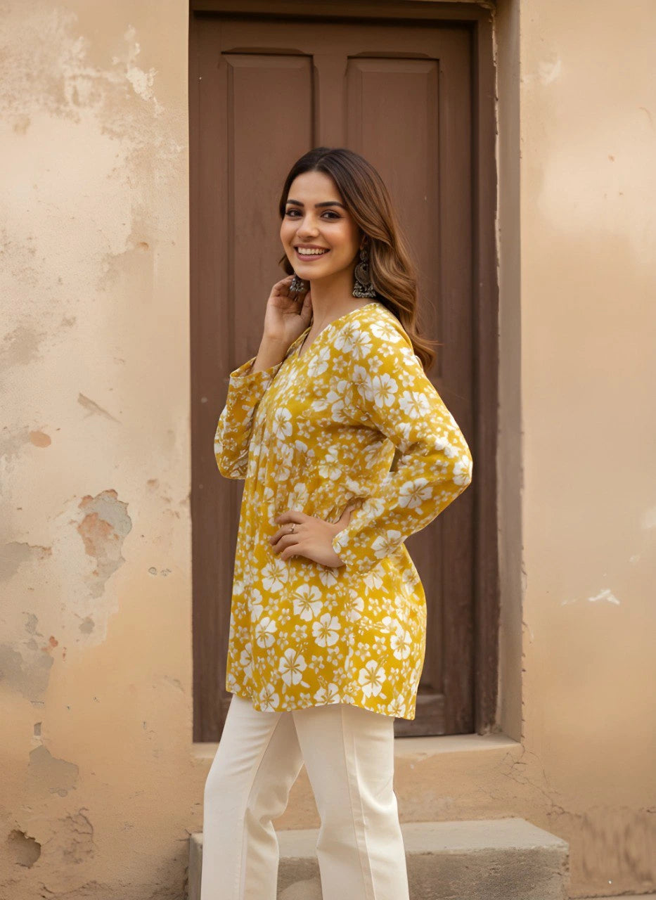 A side profile shot of the woman smiling and looking toward the camera. This angle shows the flowy drape of the kurti and how it pairs elegantly with the structured off-white trousers.