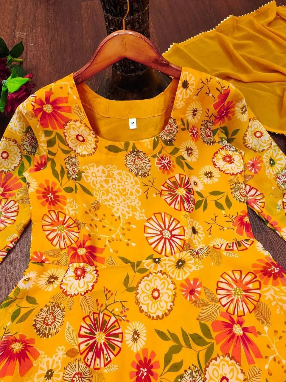 Yellow floral dress on a wooden hanger with a dark background