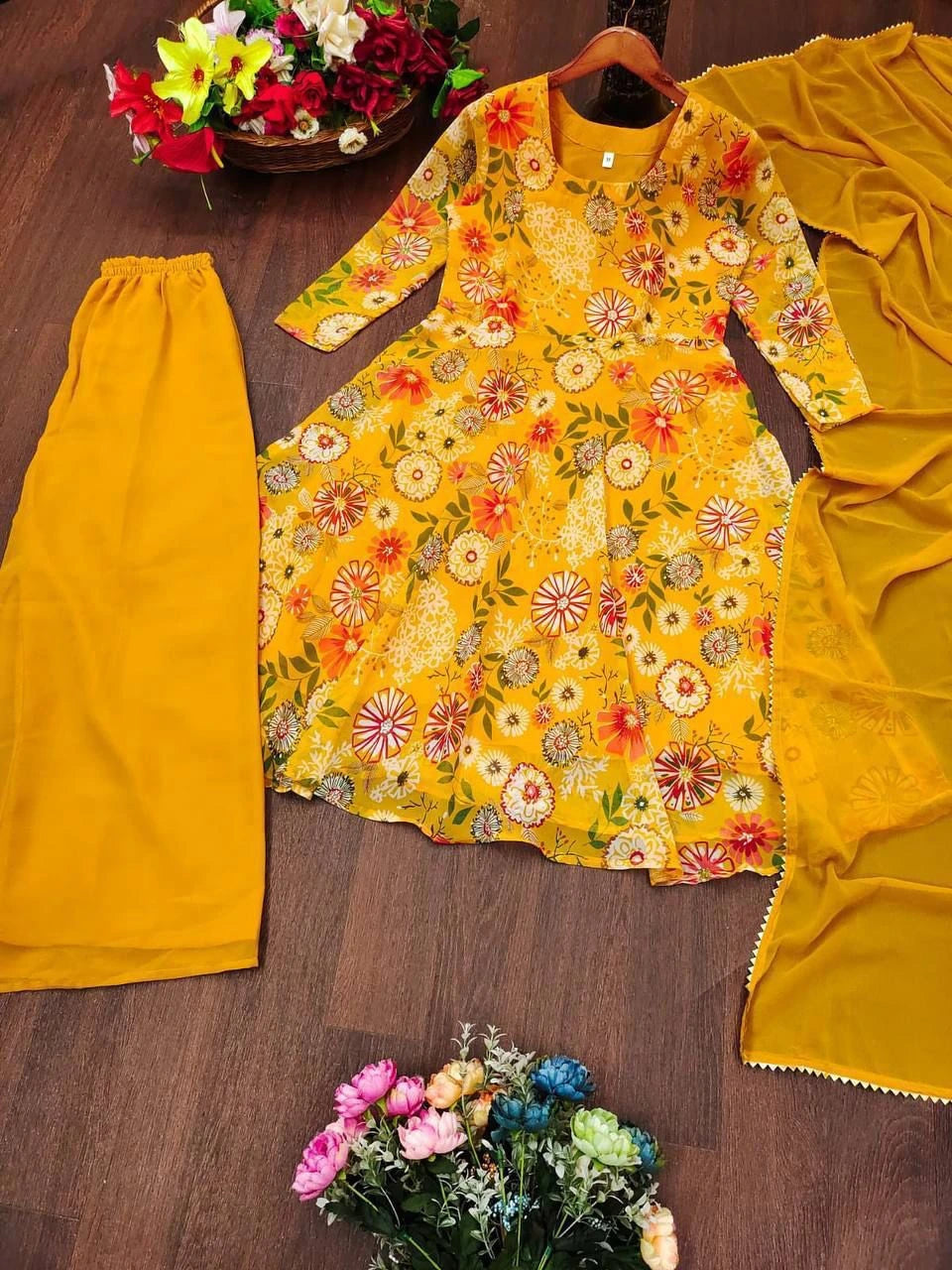 Yellow floral top with matching skirt on a wooden surface with flowers.