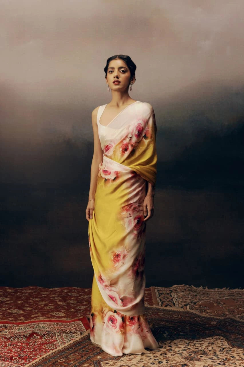 Woman wearing a floral saree with a dark background
