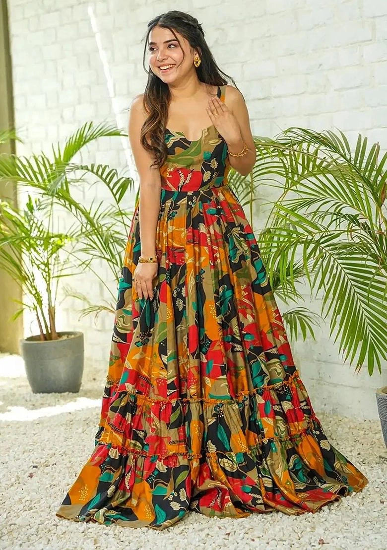Woman wearing a colorful patterned dress standing outdoors with plants in the background