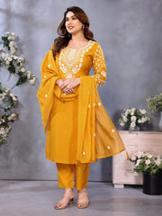 Woman in a yellow traditional outfit with floral patterns against a gray background