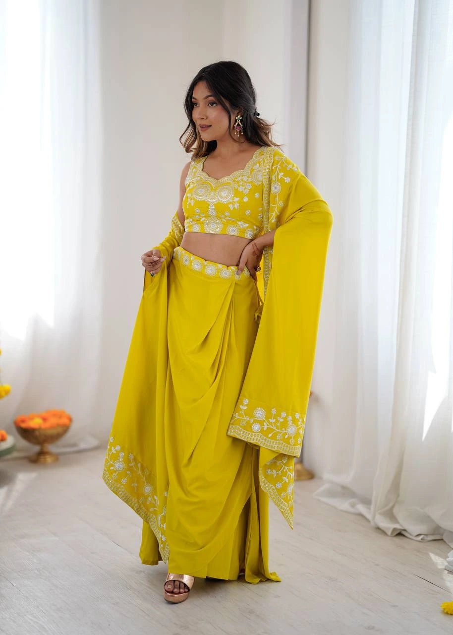 Woman wearing a yellow traditional outfit with white patterns in a bright room.