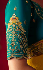Close-up of a teal fabric with gold embroidery on a red background