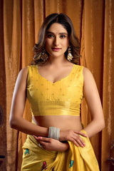 Woman wearing a yellow traditional outfit with a brown curtain background