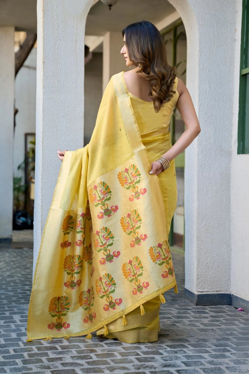 Woman wearing a yellow saree with floral patterns in an outdoor setting