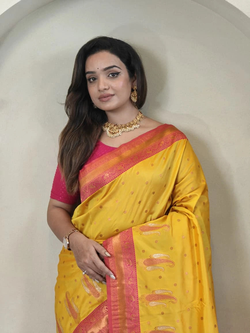 Woman wearing a yellow saree with a pink blouse against a neutral background