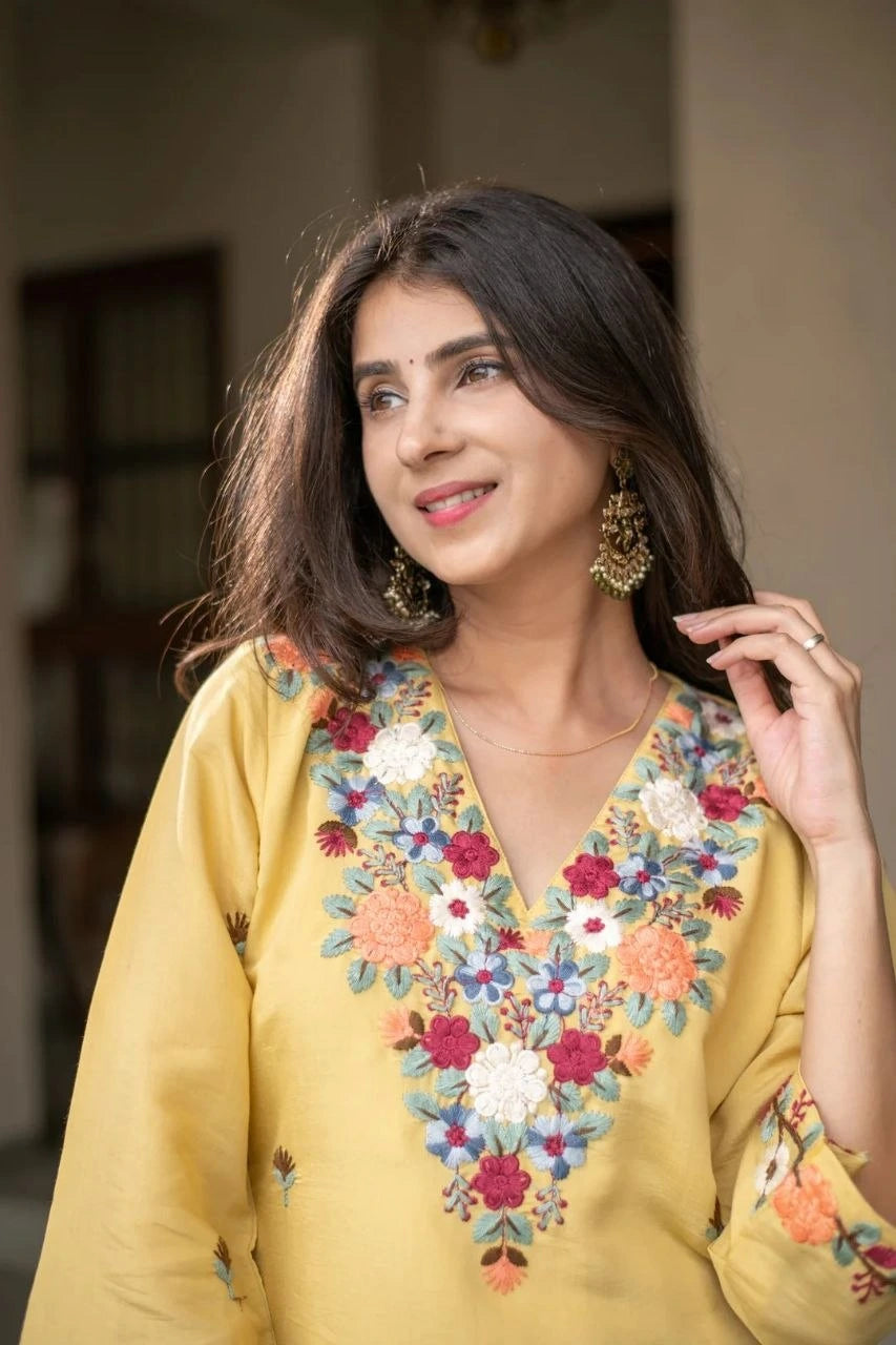 Woman wearing a yellow embroidered top with a blurred background