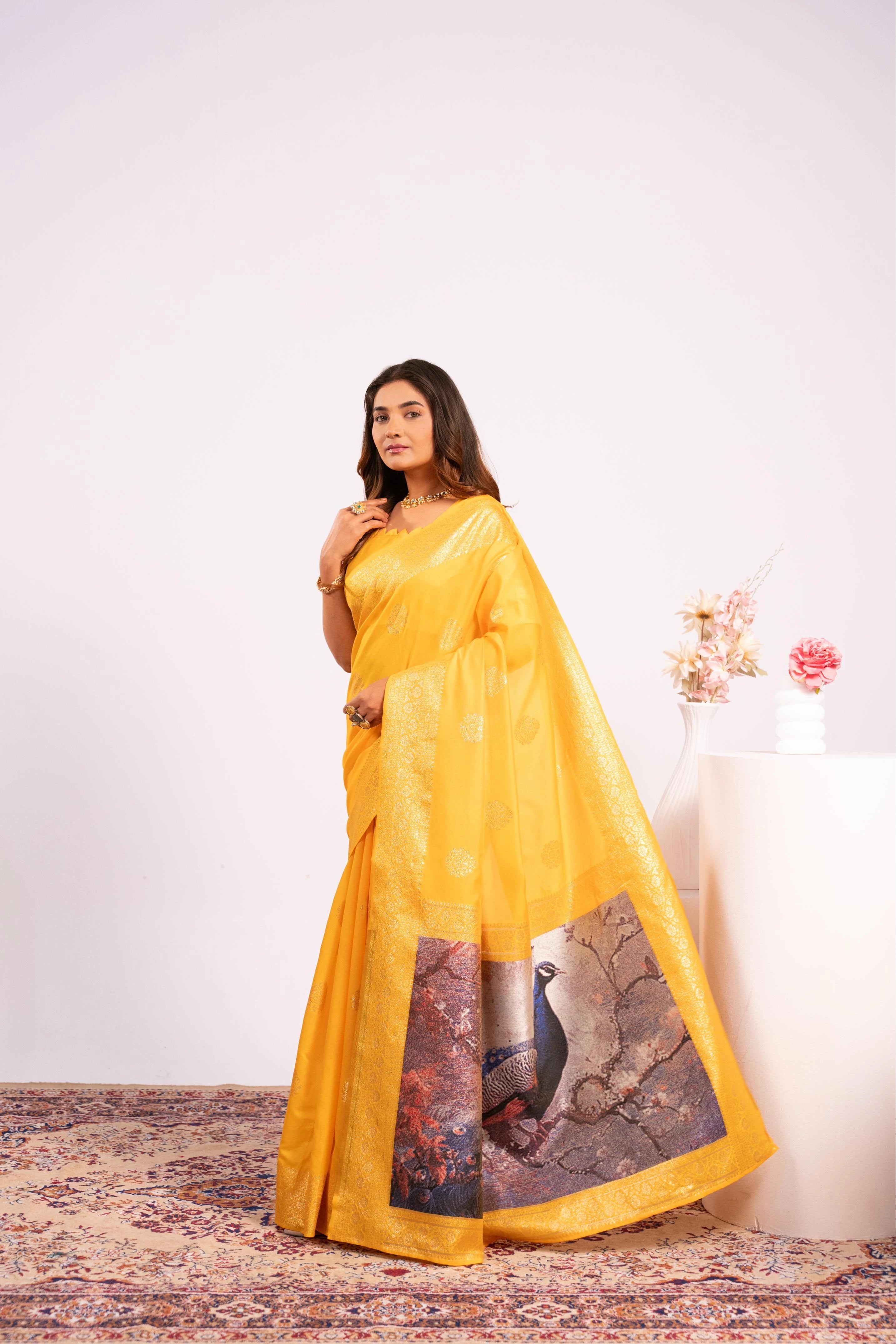 Woman wearing a yellow saree with a peacock design on a white background