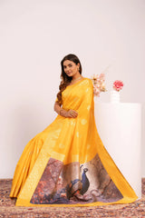 Woman wearing a yellow saree with a peacock design on a white background