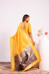 Woman wearing a yellow saree with peacock design, standing against a white background.