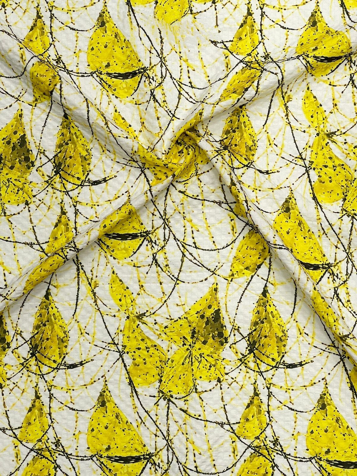 Textile with yellow leaf pattern on a white background