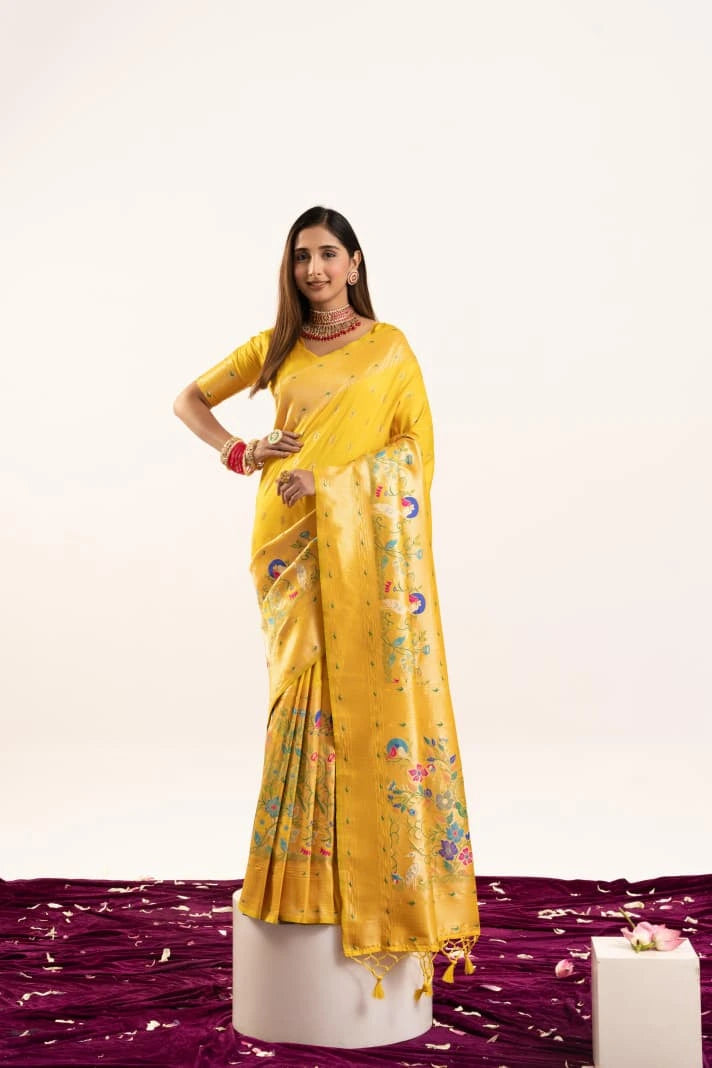 Woman in a yellow saree with a floral pattern on a white background