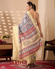 Traditional cream saree with intricate multicolor artwork and luxurious gold borders, styled with classic accessories in an indoor setting.