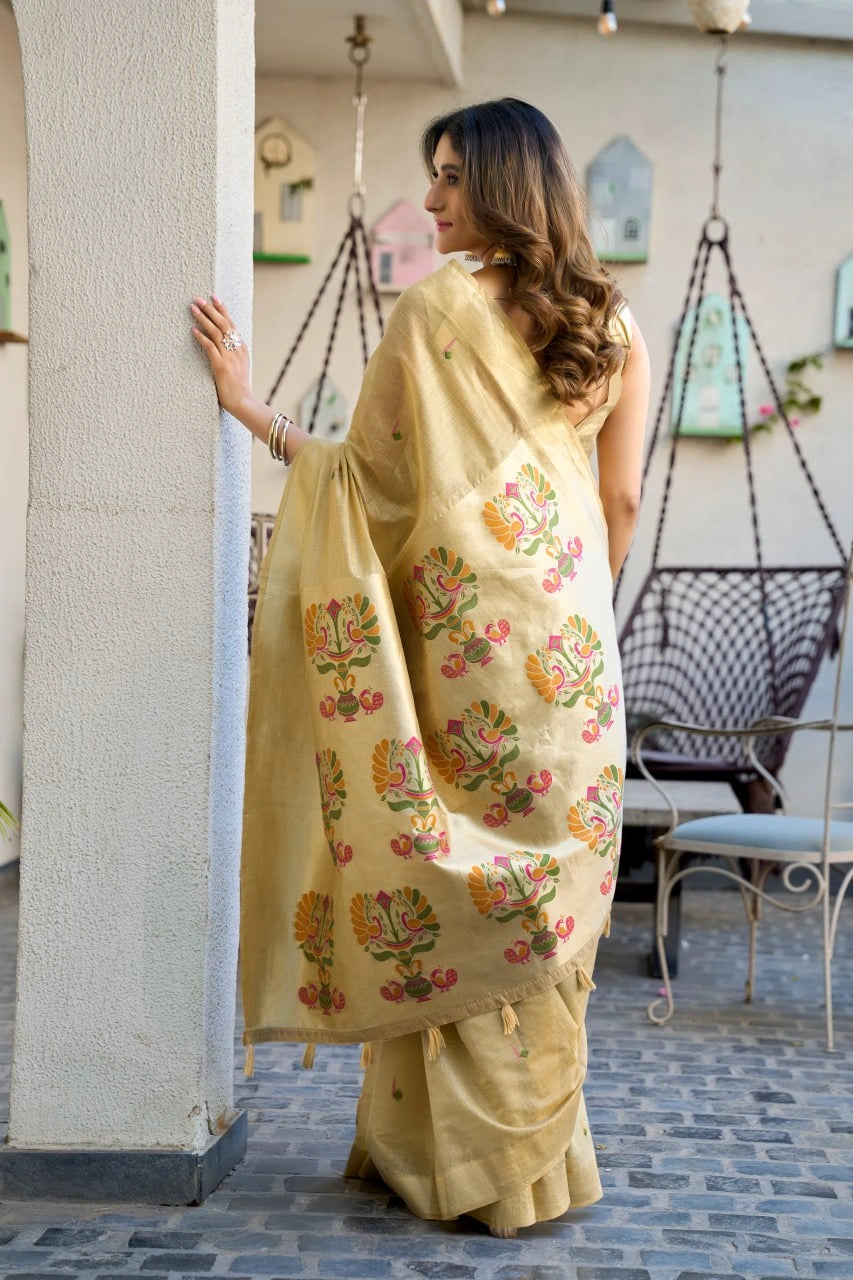 Woman wearing a beige saree with floral patterns in an outdoor setting.