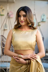 Woman wearing a gold saree with a blurred background