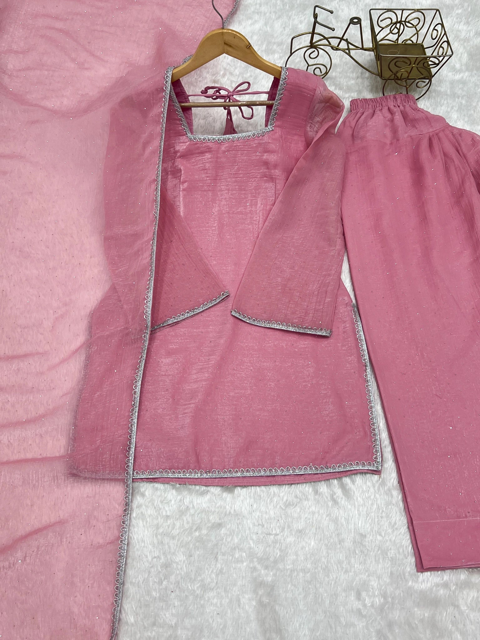 Baby pink suit flat lay - lace border detail