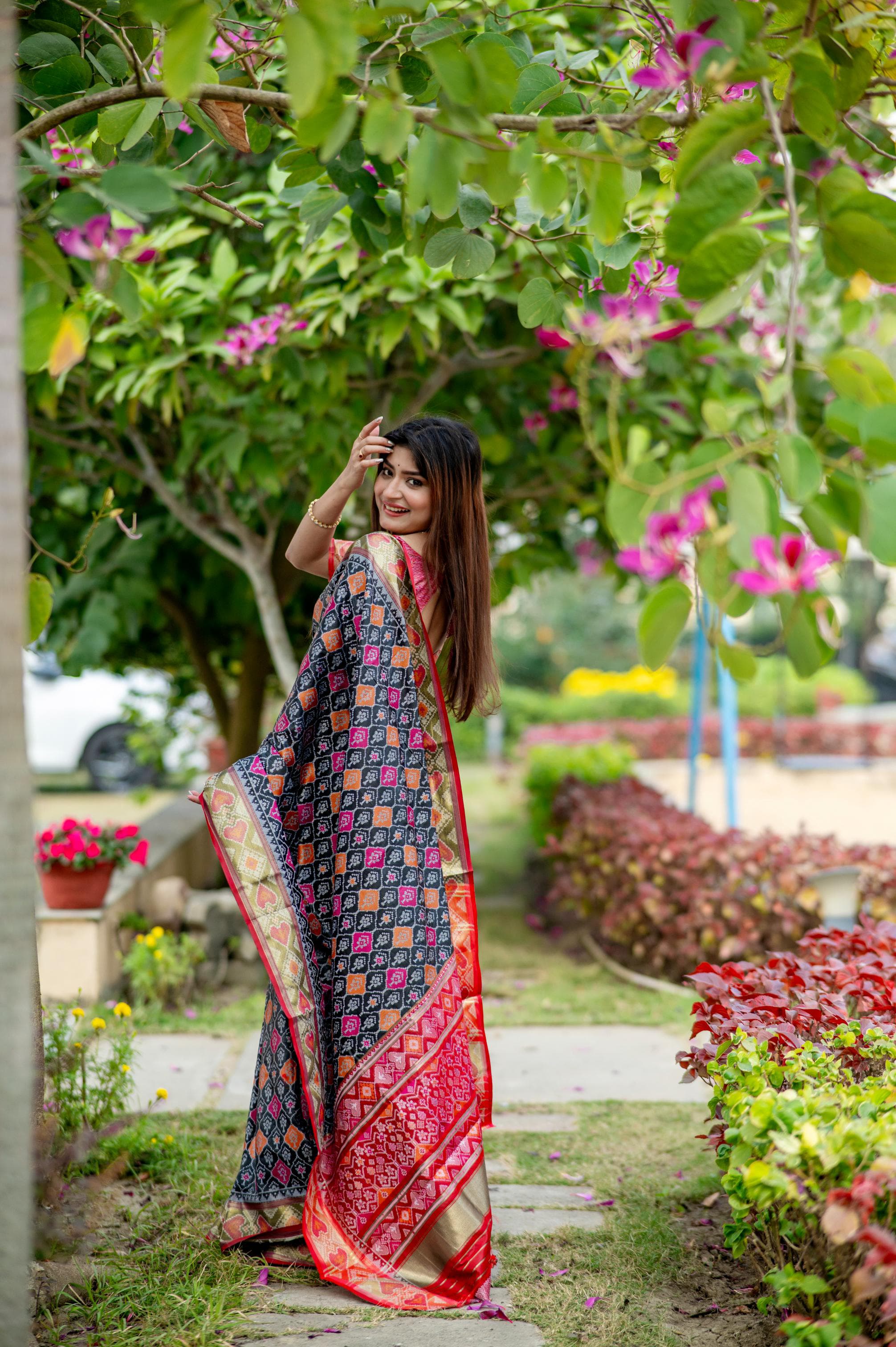 Woman wearing a blue saree with intricate zari work, showcasing traditional elegance in an outdoor setting
