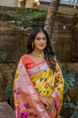 Close-up of woman in brown yellow zari work saree with intricate floral pallu, styled with traditional gold jewelry in an outdoor setting