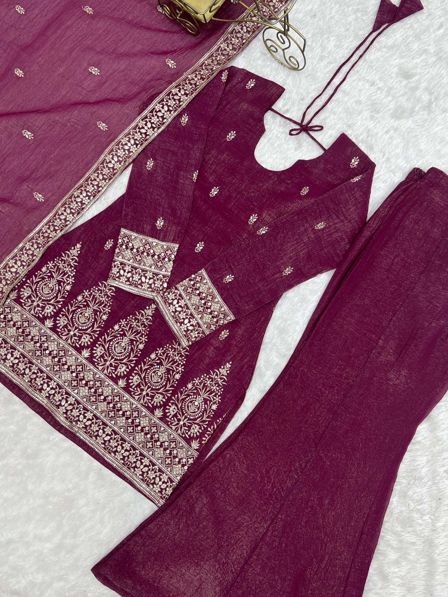 Burgundy suit flat lay - hem embroidery detail