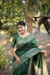 Smiling woman in dark green saree with zari work