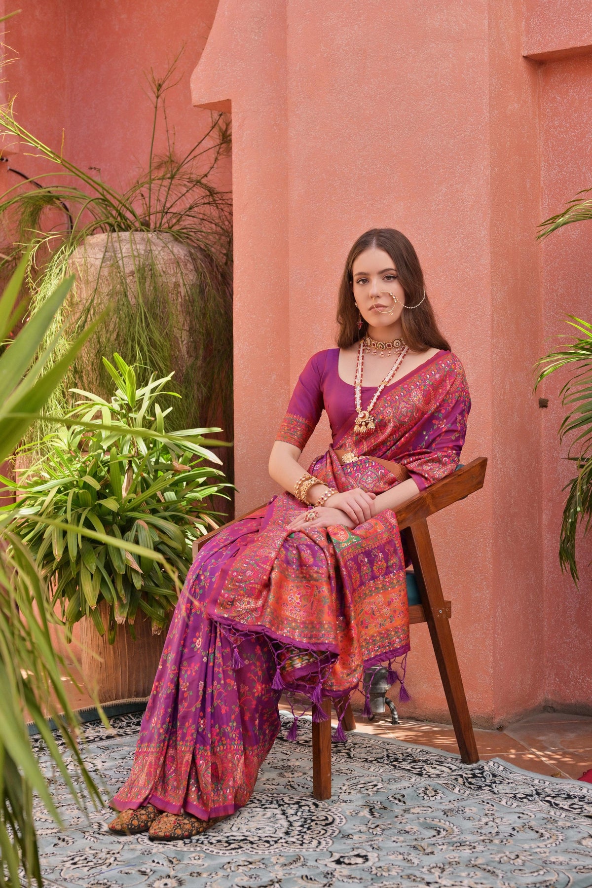 Woman in dark pink Kashmiri Jal weaving saree with rich ethnic patterns and classic Indian accessories