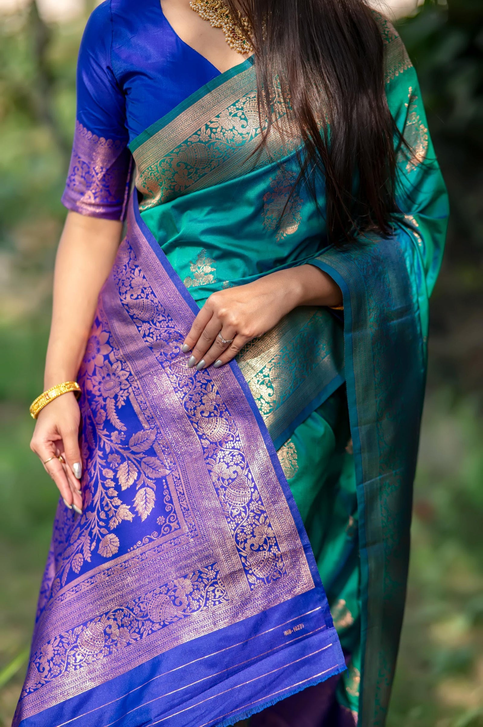 Deep teal saree with intricate zari work and blue border