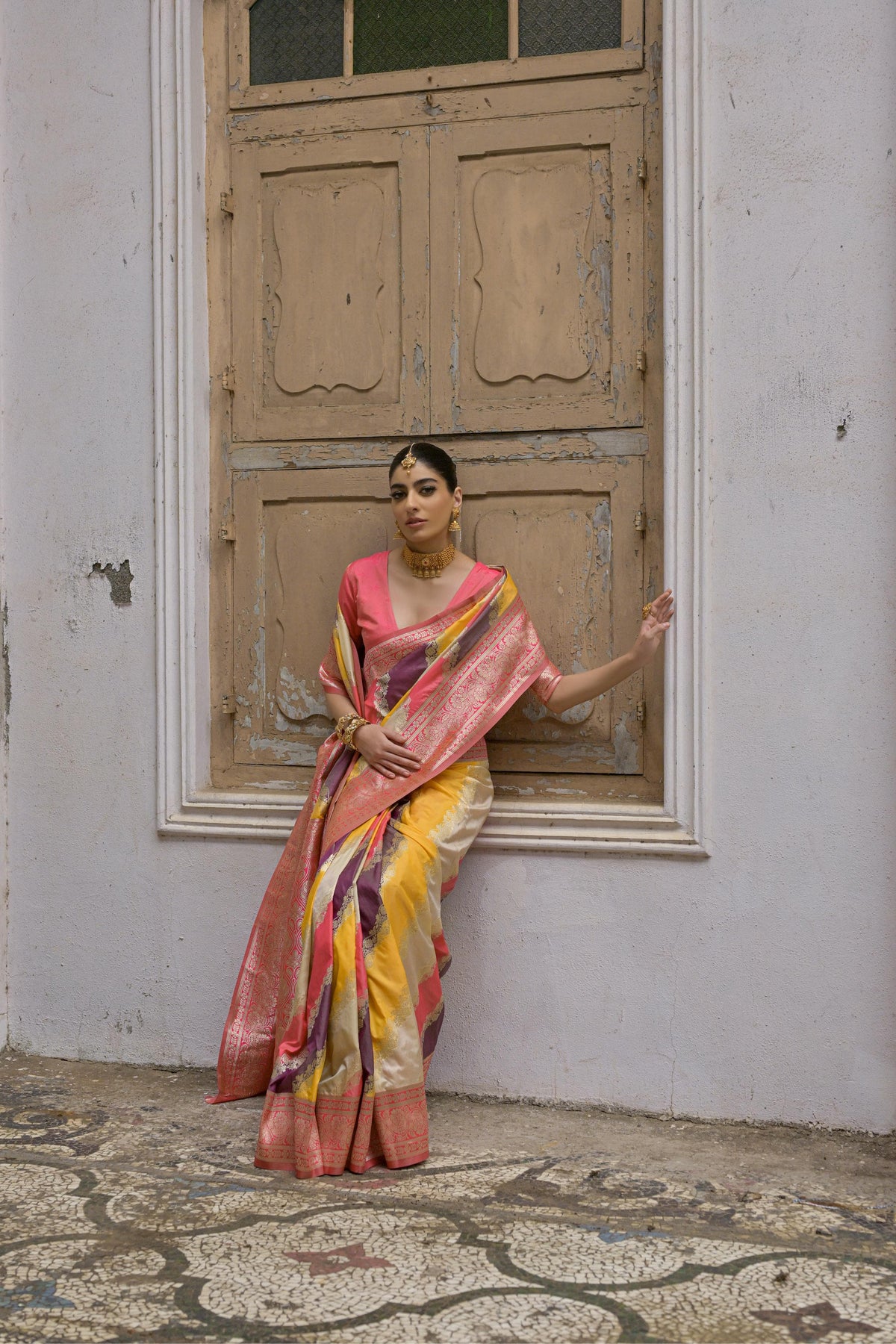Woman wearing tulip pink floral printed saree standing outdoors in elegant traditional