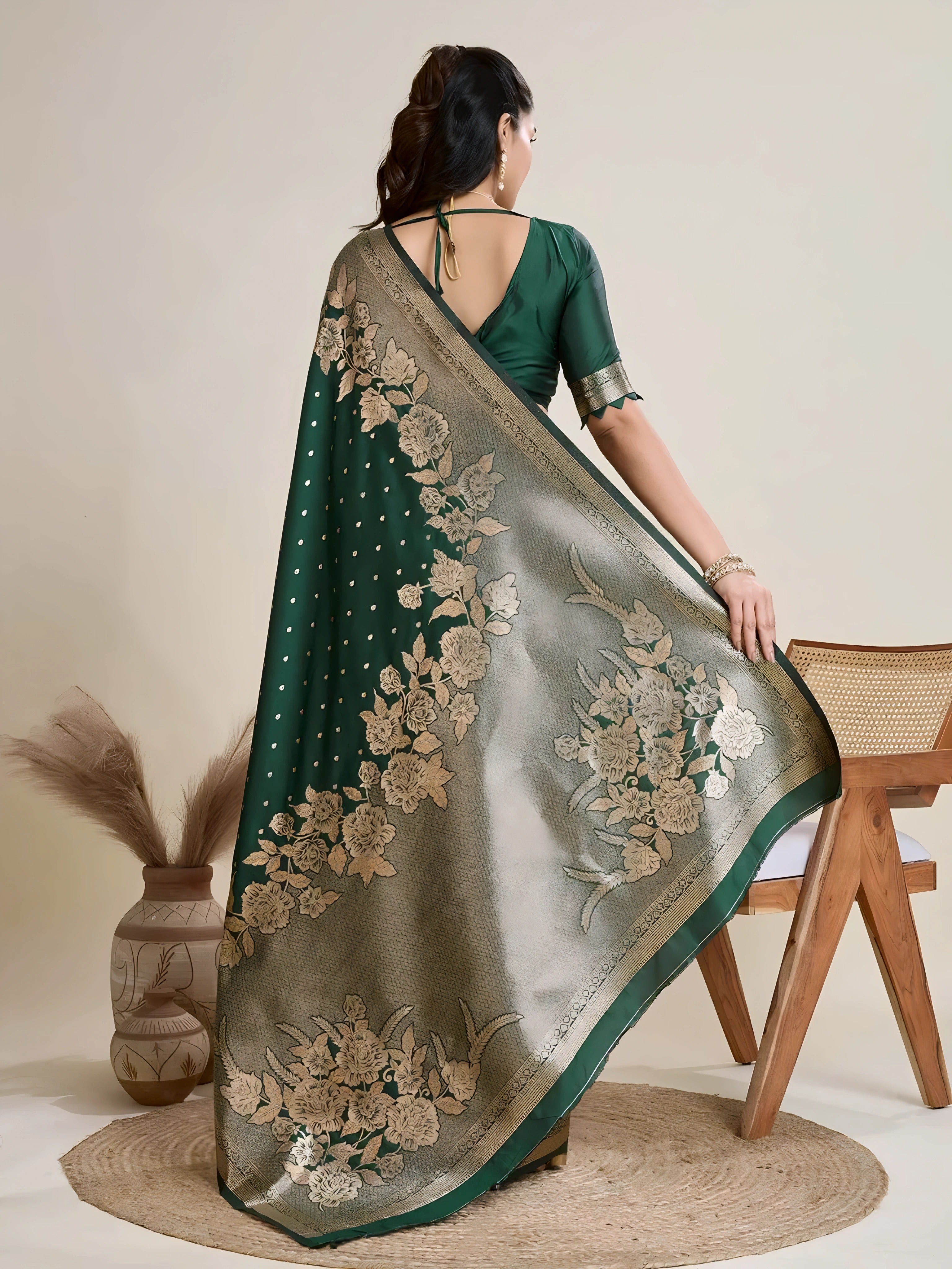 A woman models a luxurious Dark Green Soft Kanjivaram Silk Saree. The saree features striking large floral and scattered motifs woven in metallic antique gold Zari on the body and wide pallu. She wears a matching long-sleeve green blouse and accessorizes with a heavy gold Kundan choker necklace and earrings.