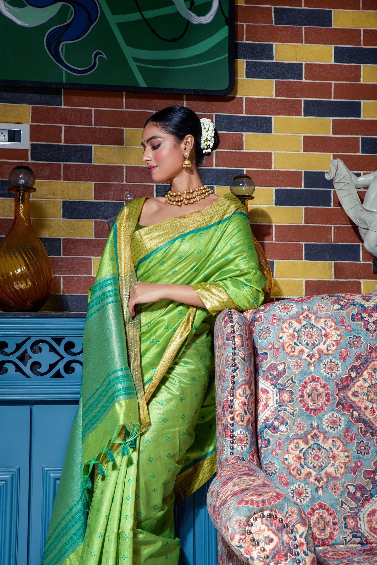 Close up of green saree with intricate zari work and blue gold border