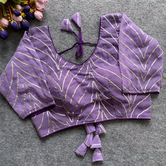 Lavender designer blouse featuring golden thread embroidery, deep back design, and matching fabric tassel tie-up