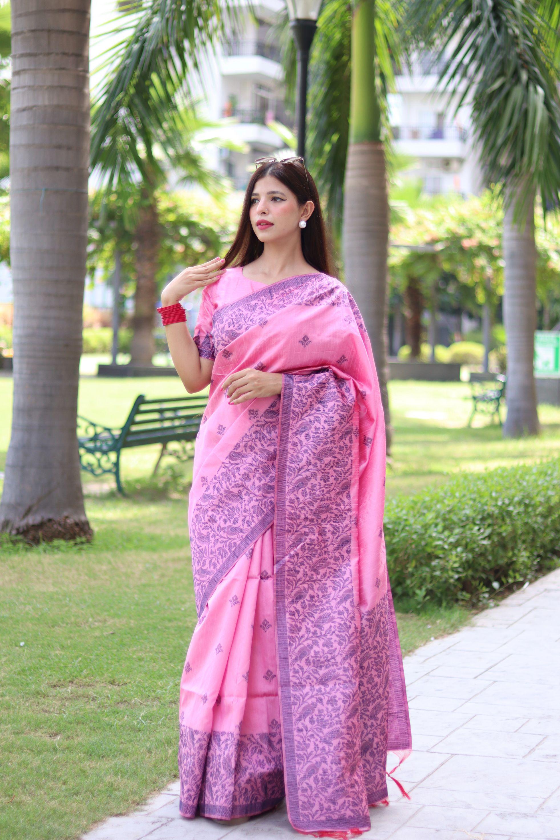 Woman in light pink traditional weaving saree showcasing elegant ethnic style in garden background