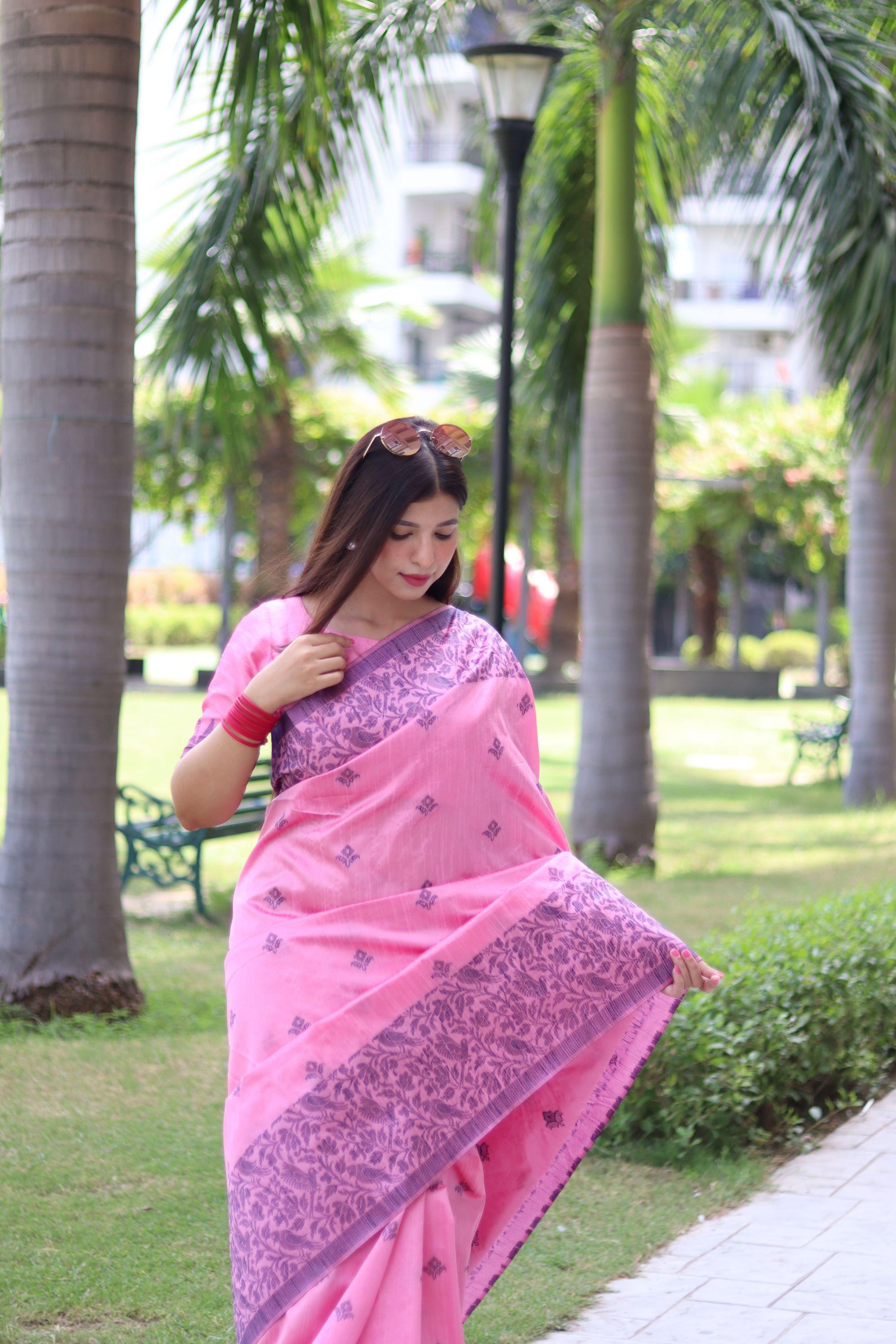 Woman in light pink traditional weaving saree showcasing elegant ethnic style in garden background